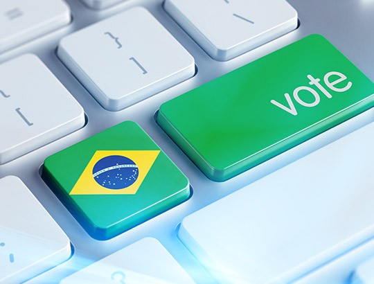 Arte de um teclado de computador com uma tecla com a bandeira do Brasil e a inscrição vote ao lado para o post Dados pessoais no marketing político do blog da LGPD Solucoes